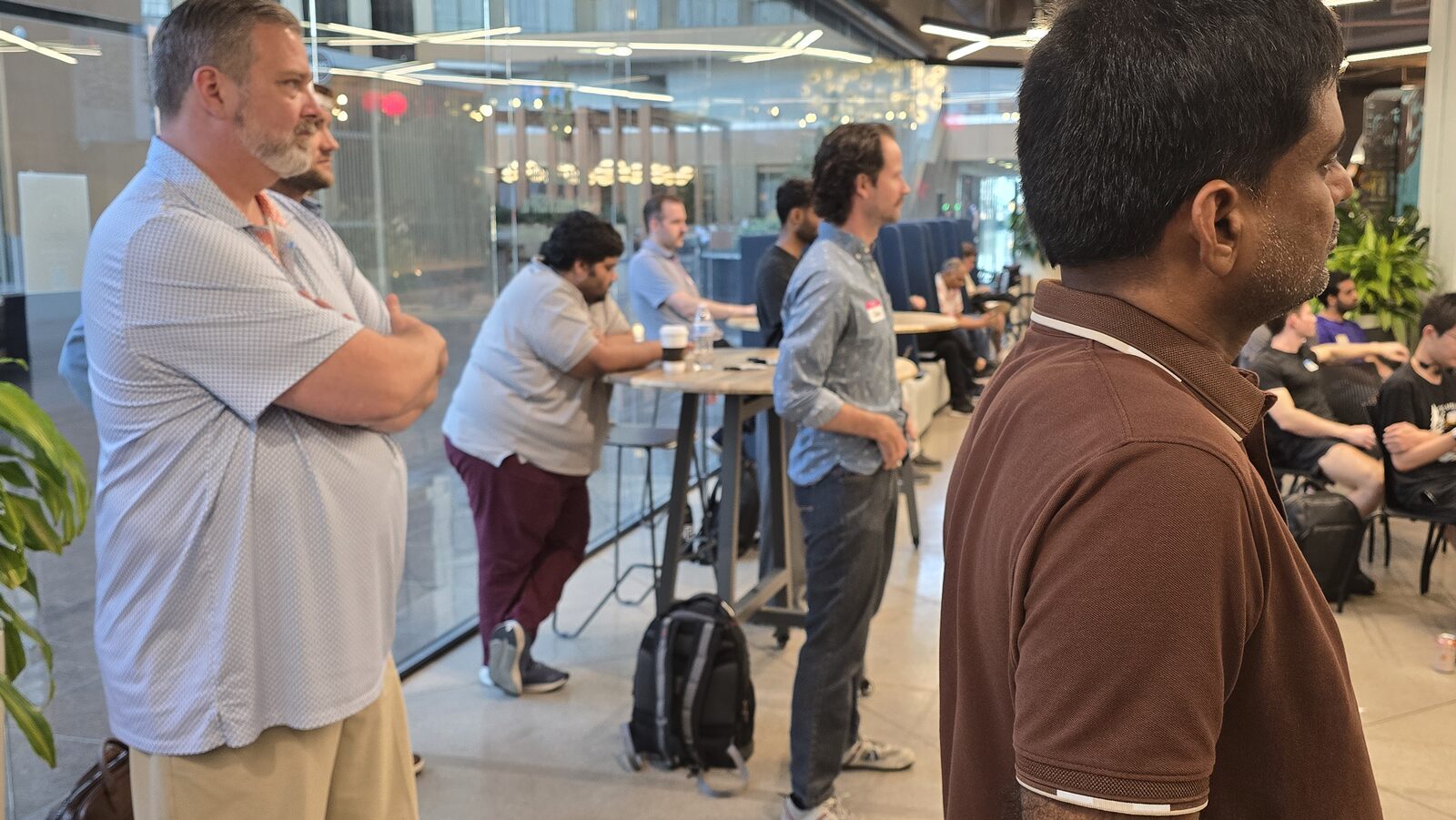 Attendees standing at the back by a high-top table