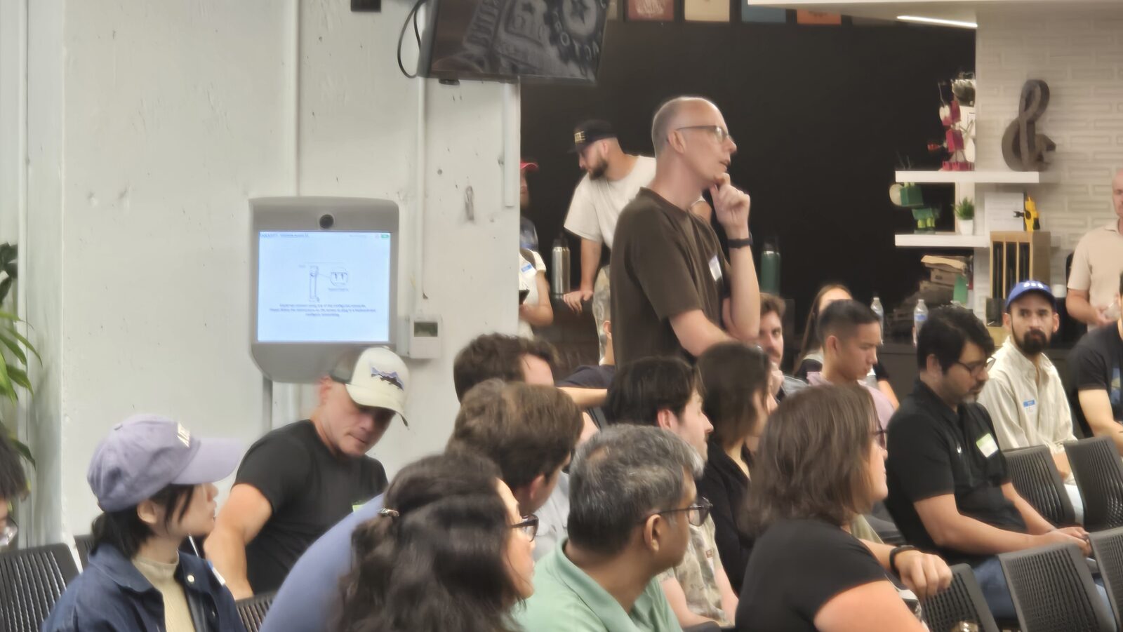 An attendee stands to ask a question during the meetup